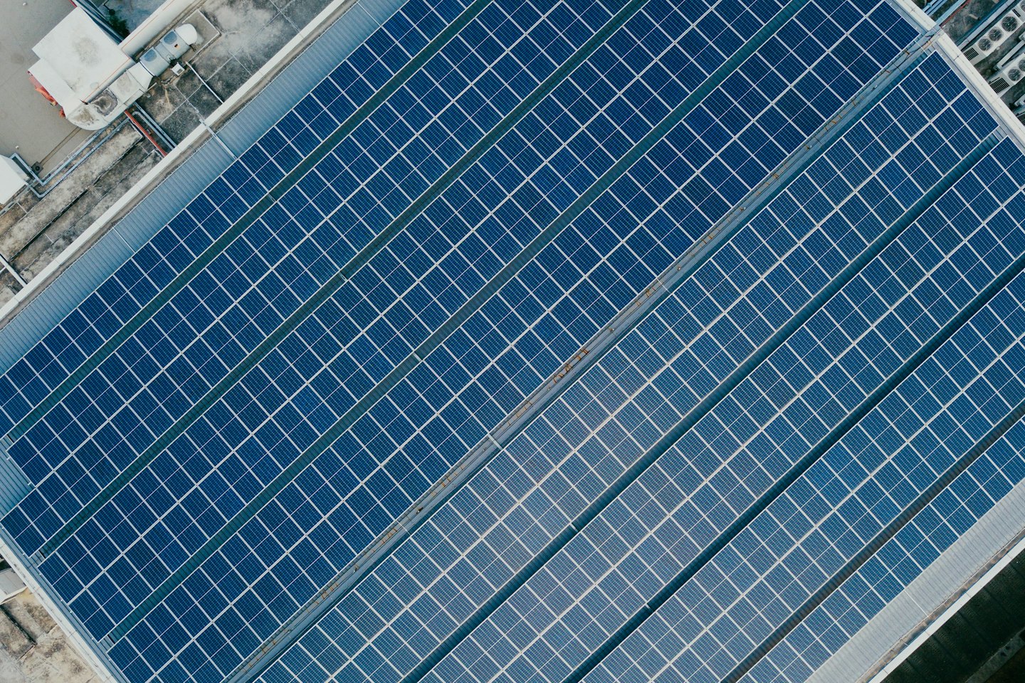 Pannelli solari blu che coprono il tetto di un grande edificio commerciale.