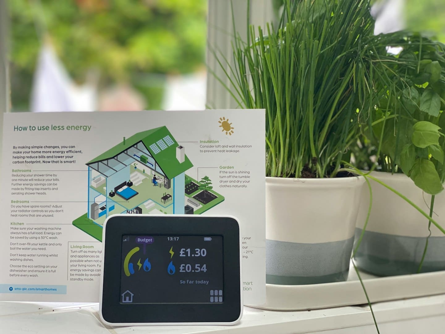 Contatore intelligente che mostra i consumi con brochure e piante.